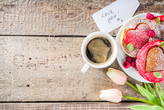 Valentine day brunch food recipe idea. Delicious homemade heart shaped red and white pancakes with berries. Concept of a festive breakfast for Valentine's Day, pleasant surprise for loved one