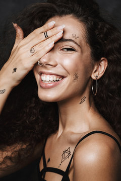 Image of young cheerful woman smiling and covering her eye