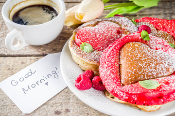 Valentine day brunch food recipe idea. Delicious homemade heart shaped red and white pancakes with berries. Concept of a festive breakfast for Valentine's Day, pleasant surprise for loved one