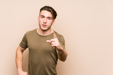 Young caucasian man posing isolated showing number one with finger.