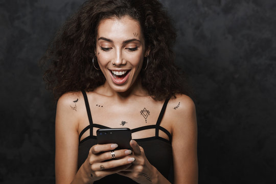 Image of nice delighted woman smiling and using cellphone
