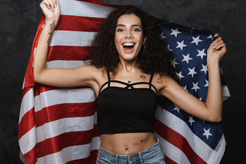 Image of young caucasian woman smiling and holding american flag