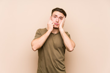 Young caucasian man posing isolated whining and crying disconsolately.