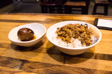 Lo bah png, traditional Taiwanese rice dish (minced pork rice) with seasoned boiled egg on table. Lo bah png is a type of gaifan dish that is commonly seen throughout Taiwan and Southern Fujian.