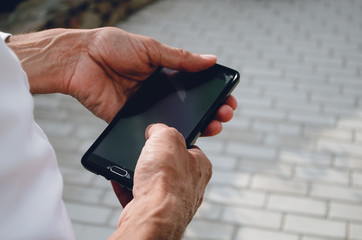 The man is holding a phone with a black screen