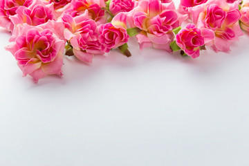 Simple decorative background with pink roses on the top of image and copy blank empty space in the center.