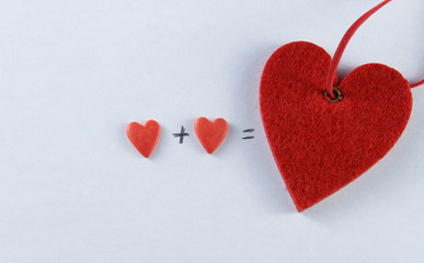 closeup image of two red hearts with a plus and equal sign on a white background, valentines day, valentines day