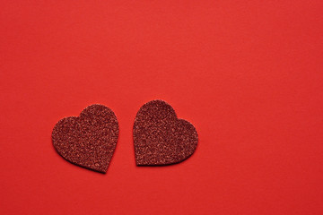 two heart shaped glitter hearts on red background with copy space - valentines day wedding or...