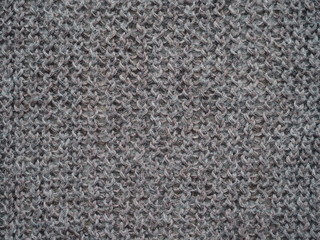 Knitted fabric texture. Gray. Simple knitting with front and back loops. Knitting on the knitting needles. Horizontal lines.