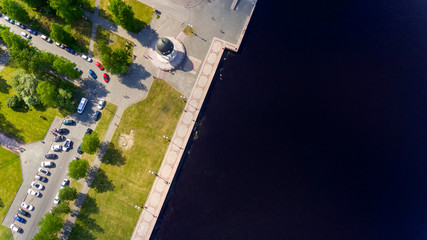 Aerial view of city park on lake embankment and parked cars in Russia