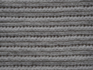 Knitted fabric texture. Gray. Simple knitting with front and back loops. Knitting on the knitting needles. Horizontal lines.