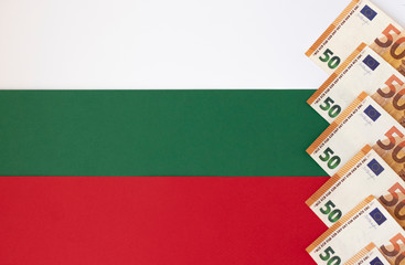 Euro banknotes on the background of the national Bulgarian flag. The entry of Bulgaria into the eurozone. The single currency of the euro area and the national flag of Bulgaria. Concept.