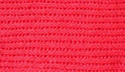 Knitted fabric texture. Red color. English knitting with front and back loops. Knitting on the knitting needles. Horizontal lines