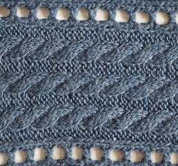 Knitted fabric texture. Blue color. Knitting on the knitting needles. Combined openwork knitting. Knitted background.