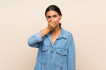 Young woman over isolated background covering mouth with hands