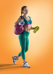 Sport backgrounds. Beautiful slim sporty young girl is preparing for joint training.  Fitness concept.