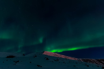 Aurora borealis in night northern sky. Ionization of air particl