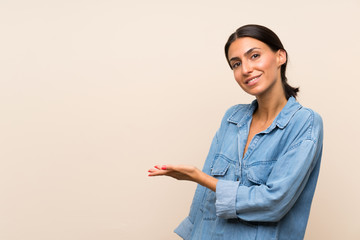 Young woman over isolated background presenting an idea while looking smiling towards