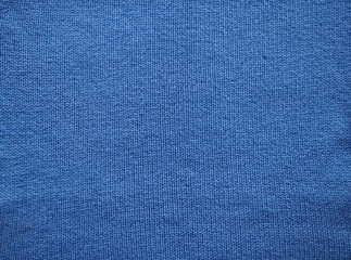 Knitted fabric texture. Blue. Garter stitch with facial loops. Knitting on the knitting needles. Knitted background.