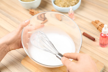 Woman making natural handmade soap at wooden table, closeup