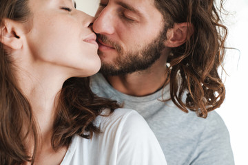 Kissing loving couple indoors at home.