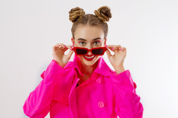 Happy, shock, excited woman face closeup. Girl in bright pink autumn clothes, red sunglasses isolated on white background, copy space. Beautiful female surprised, cheerful. Fun funny model screaming