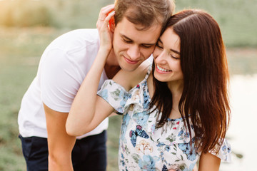 Portrait of happy couple outdoor in nature location at sunset.