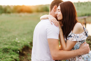 Fototapeta premium Portrait of happy couple outdoor in nature location at sunset.