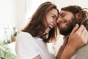 Loving couple indoors at home posing hugging.