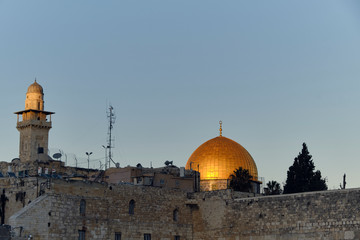 Wall of Jerusalem's Old City and clear blue sky with clouds in a sunny day, Israel.