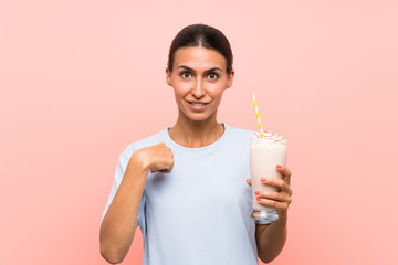 Young woman with strawberry milkshake over isolated pink background with surprise facial expression