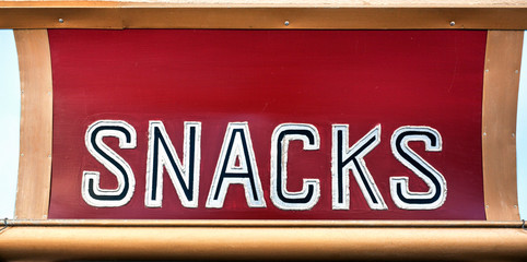 Isolated handmade wooden SNACKS sign.