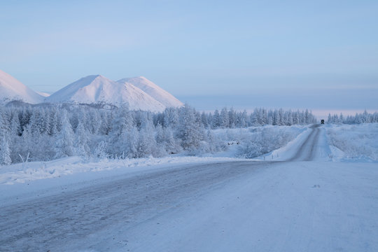 Ust-Nera, Oymyakonsky District/Sakha Republic, Russia. Winter landscape with snowy mountain road at dusk. Yakutian highway Kolyma, also called the road on bones