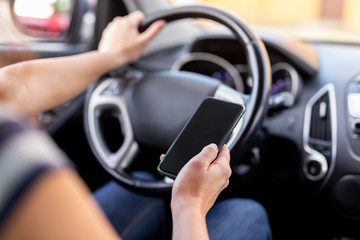 Woman using a phone and driving a car
