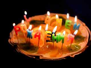Cake with burning candles "Happy Birthday"