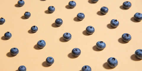 pattern of fresh blueberries is laid out on a yellow background