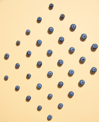 pattern of fresh blueberries is laid out on a yellow background