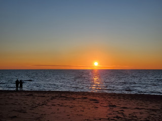 Couple of people looking at burning sunset sky sea horizon in cilento,italy,love