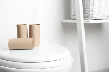 Empty paper rolls on toilet seat in bathroom