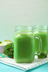 Tasty fresh kale smoothie on light blue wooden table