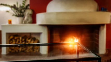 Table background of free space and blurred home interior with fireplace 