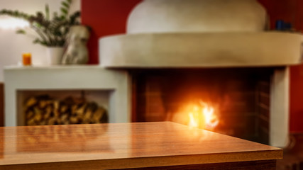 Table background of free space and blurred home interior with fireplace 