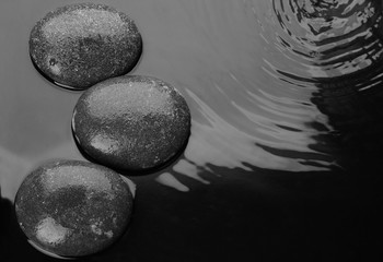 Spa stones in water, top view with space for text. Zen lifestyle