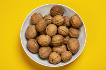 plate with walnuts on a yellow background