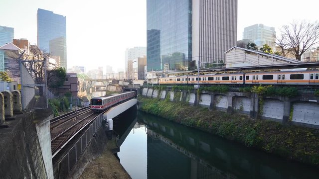 Train passing on the bridge in the Tokyo city across the bridge and city view in the background.Tokyo's train/subway train moving in city center of Tokyo.Tokyo Olympic 2020 4K UHD video transportation