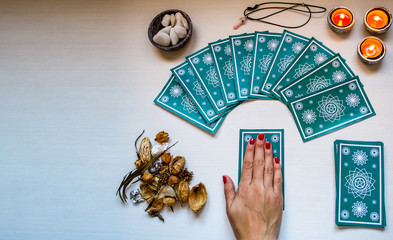 fortune teller with green tarot cards on a white wooden table ba - obrazy, fototapety, plakaty