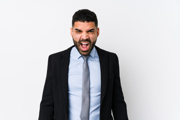 Young latin business woman against a white background isolated screaming very angry and aggressive.