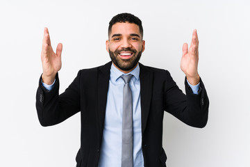 Young latin business woman against a white background isolated receiving a pleasant surprise, excited and raising hands.