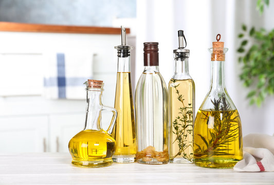 Different sorts of cooking oil in bottles on table indoors