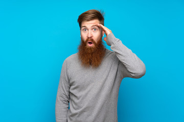 Redhead man with long beard over isolated blue background has just realized something and has intending the solution